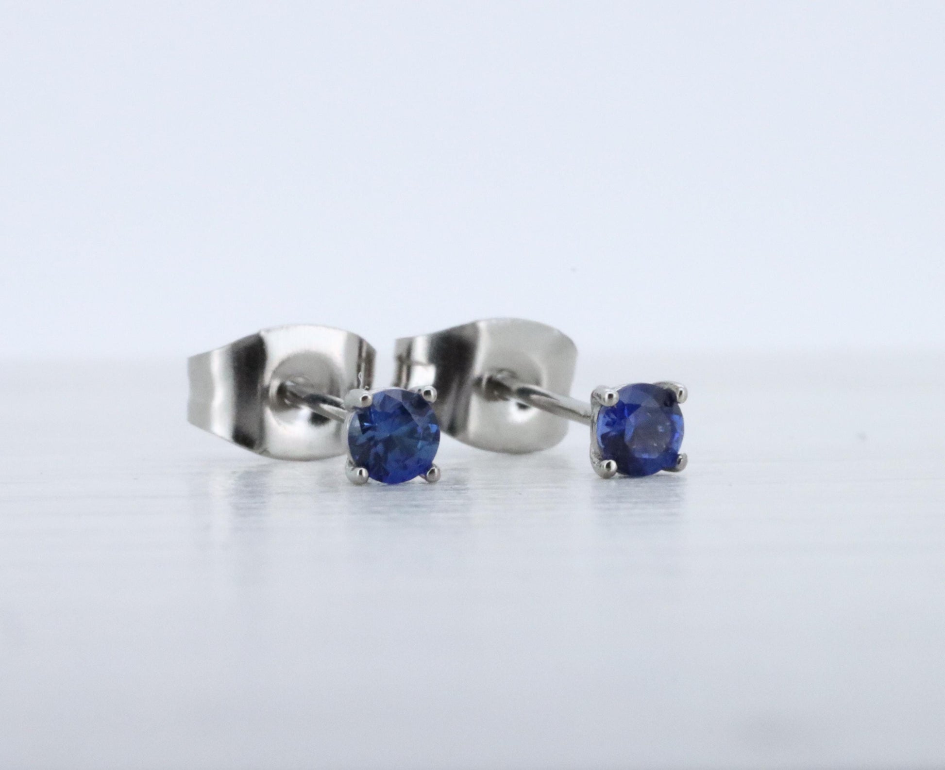 3mm Lab blue sapphire stud earrings, available in titanium, white gold and surgical steel